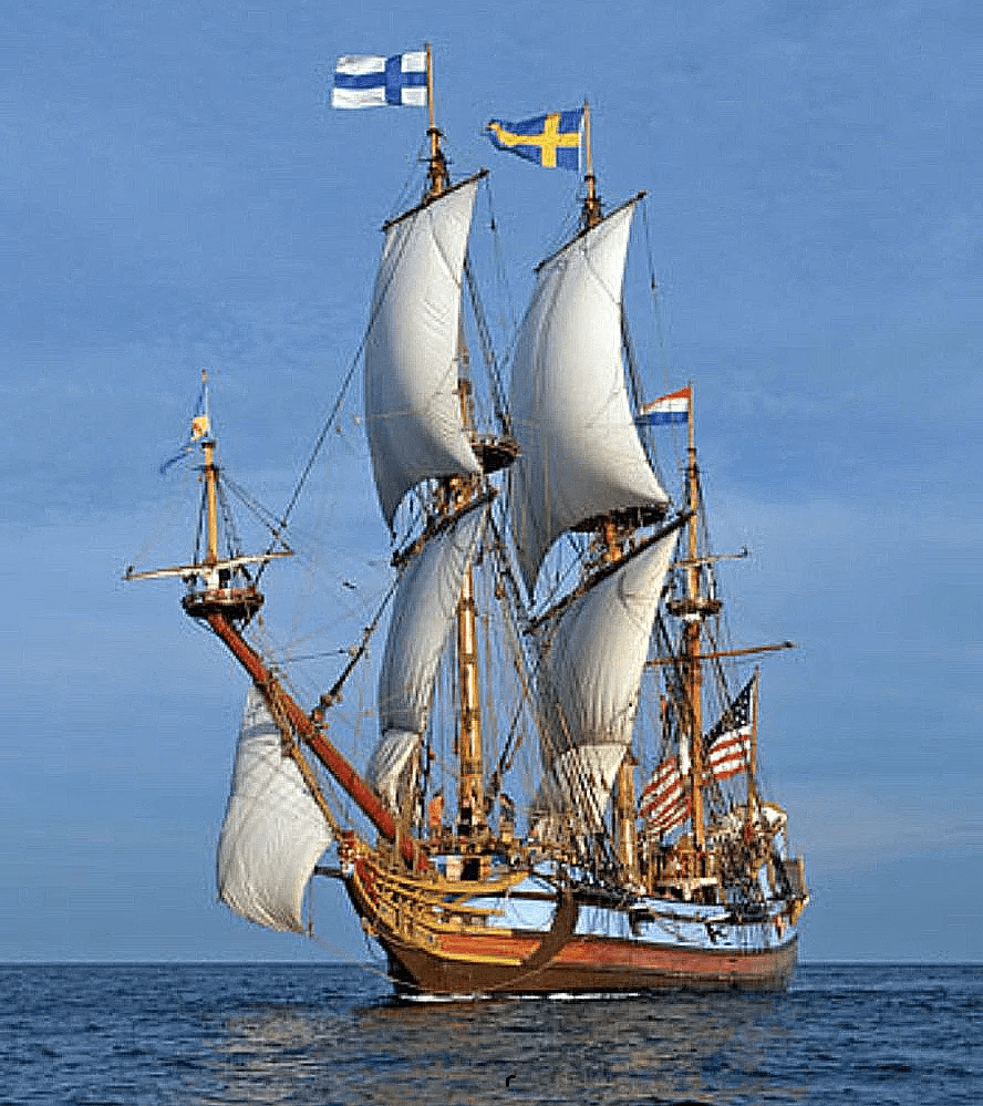 Tall ship sailing with multiple national flags.