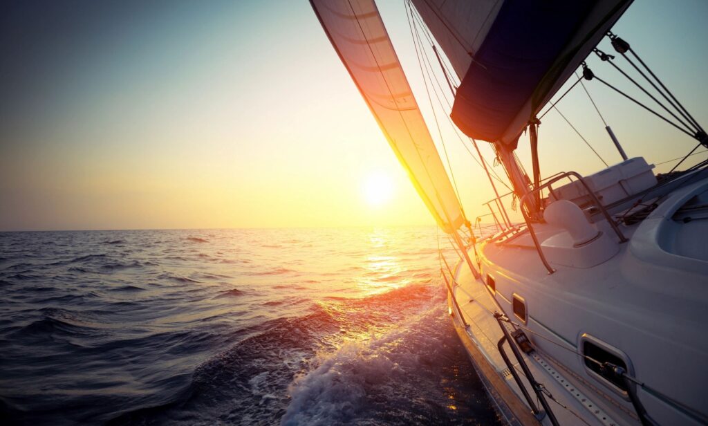Sailing boat at sunset on the ocean.