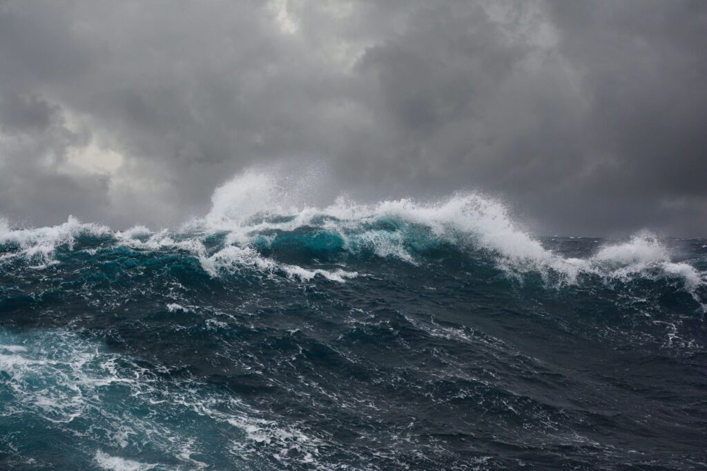 Dark stormy ocean waves under a cloudy sky.