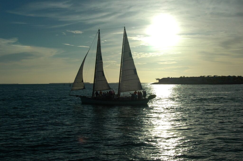 Sailboat on ocean during sunset.