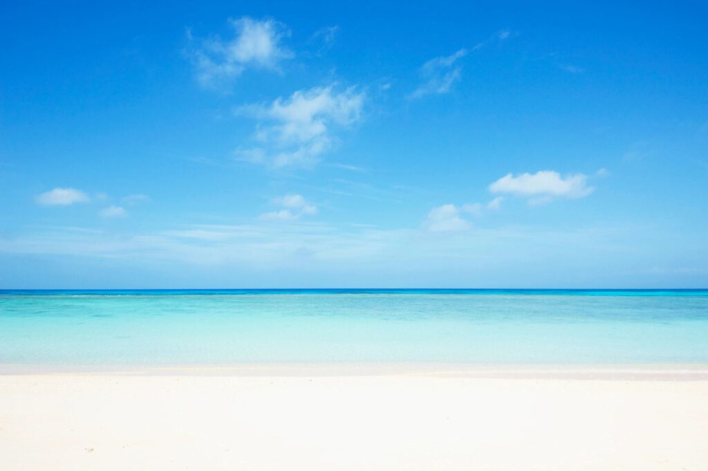 Pristine beach with clear blue sky.