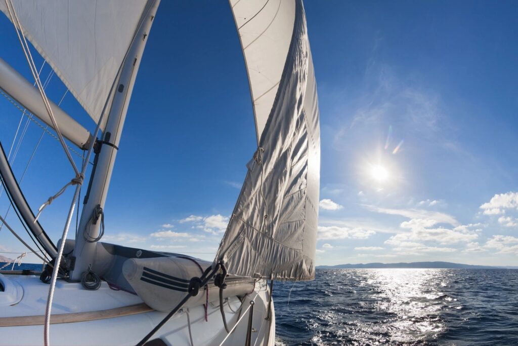 Sailboat on ocean under clear blue sky.