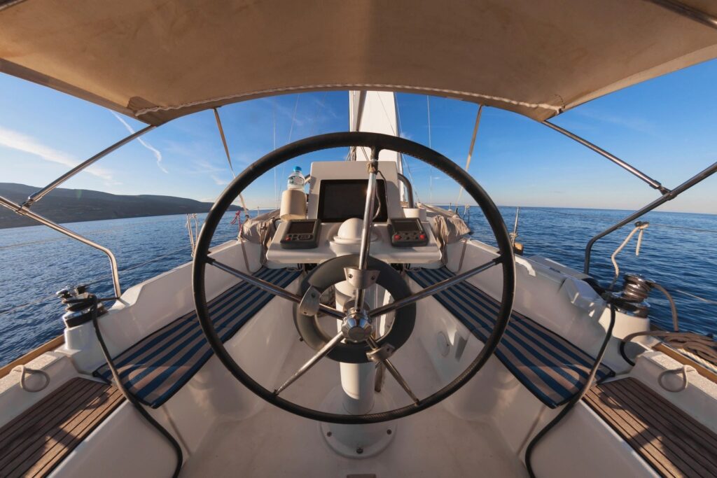 Sailboat steering wheel with ocean view.