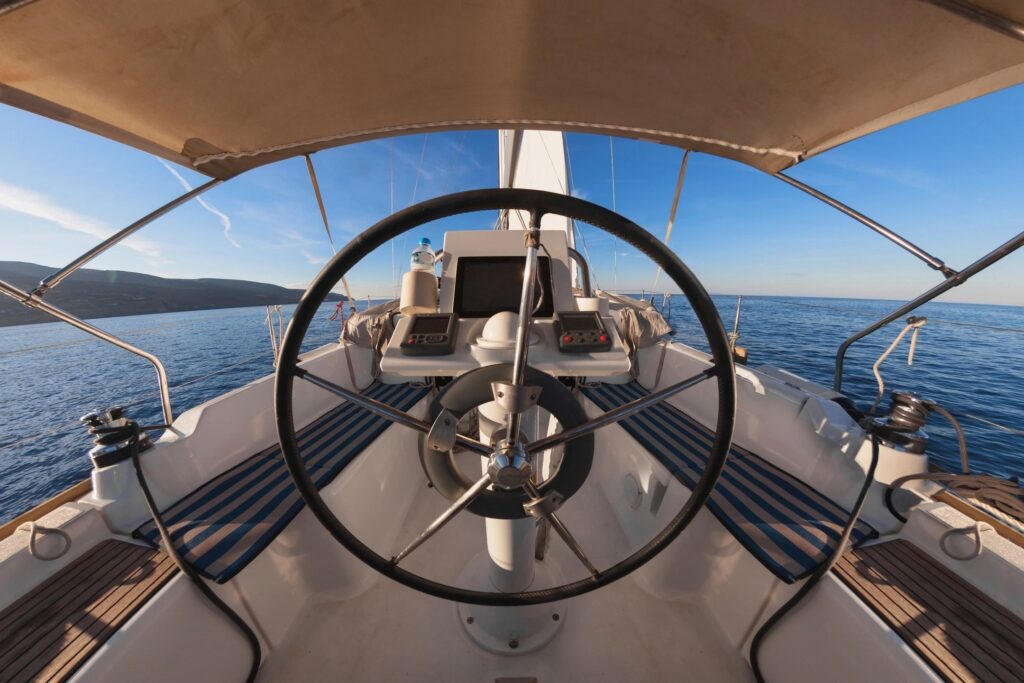 Sailboat cockpit with wheel facing open sea